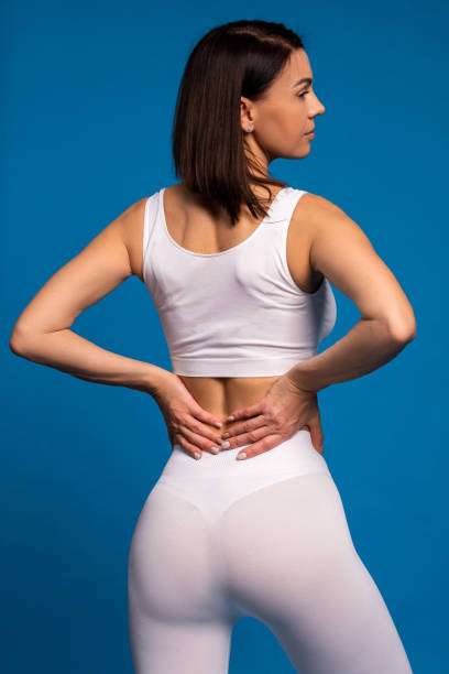 Woman in white athletic wear, showcasing subtle shaping effect similar to shapewear, back view.